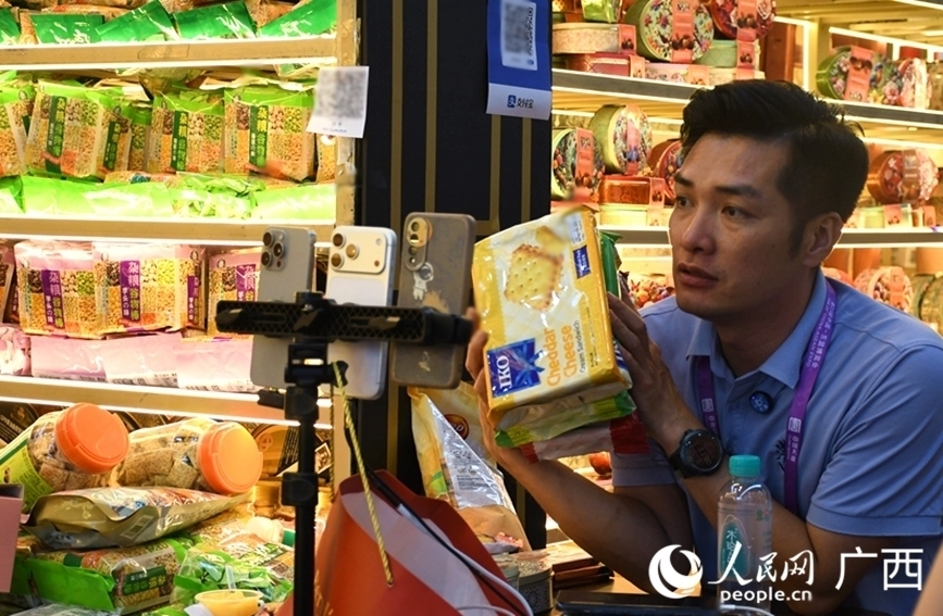 东博会上，参展商直播推介特色好物。人民网 庞惠文摄