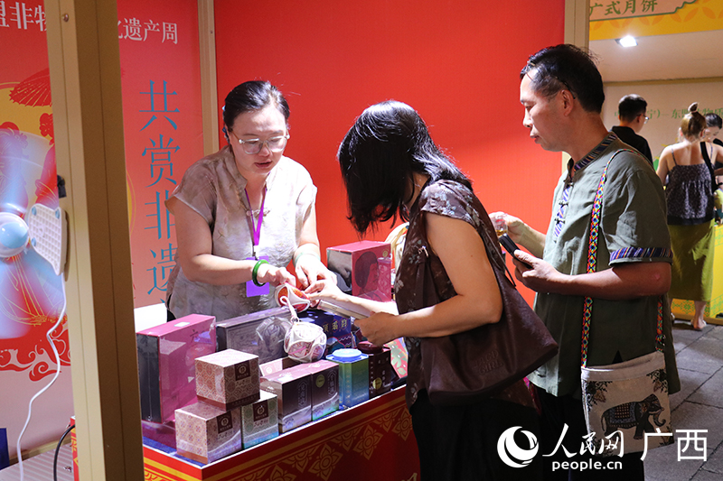 梧州六堡茶摊位前，市民游客闻香问茶。人民网 刘璐瑶摄