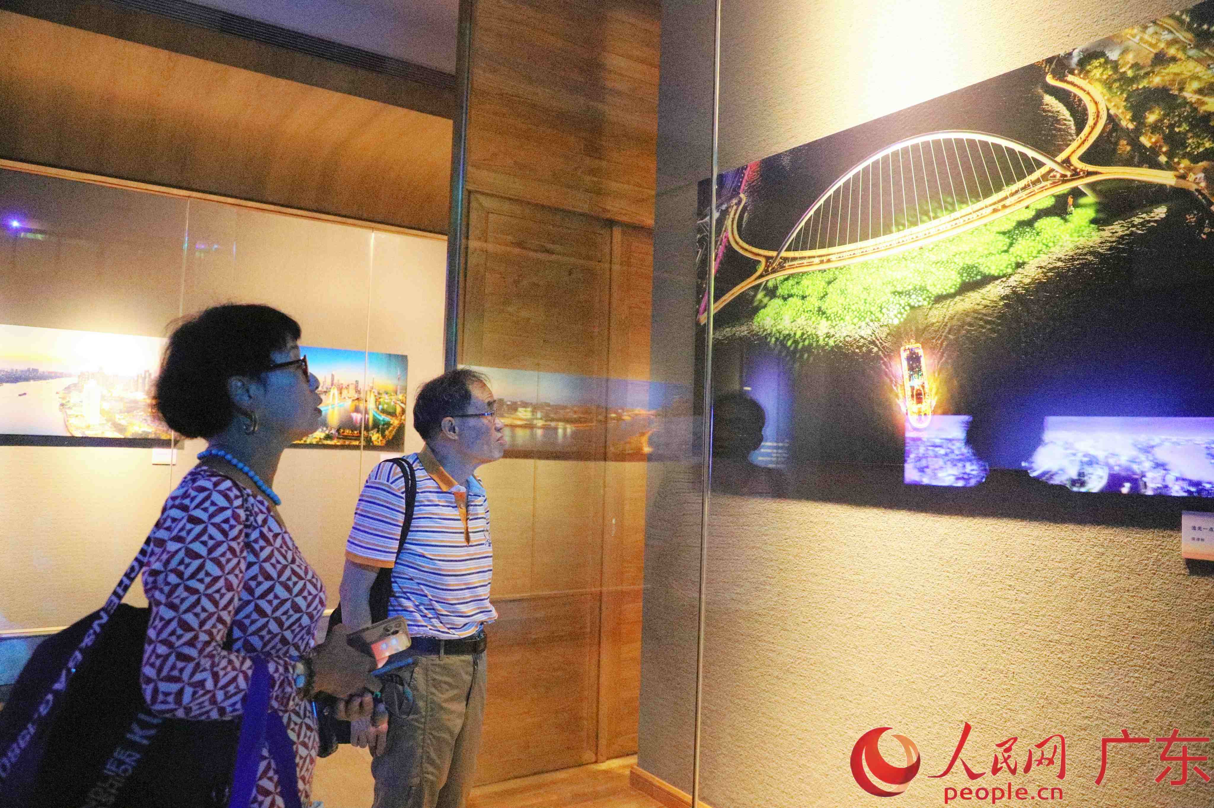 参展摄影师唐谭敏向参观市民分享作品《流光一点萤》的创作故事。人民网 杨健楠摄