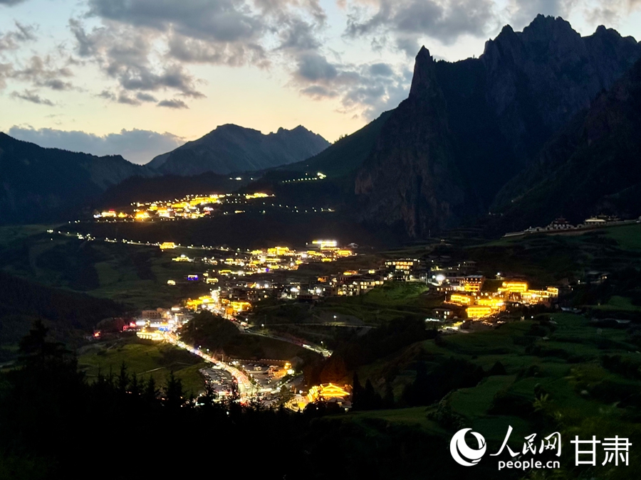 远眺扎尕那夜景,群山隐入夜色,村中灯火明亮。人民网记者 焦隆摄