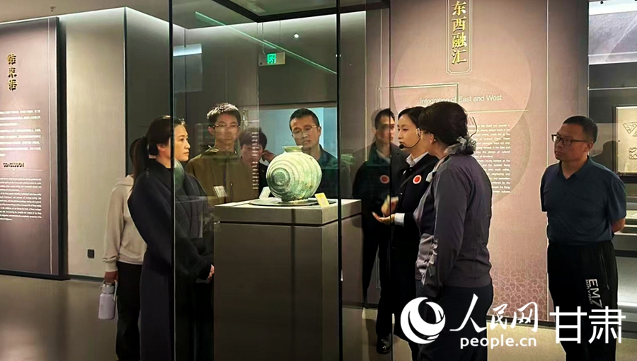 游客驻足展柜前,听讲解员讲述马家塬遗址出土文物背后的故事。人民网记者 米媛摄
