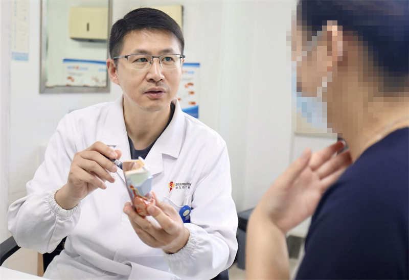 武汉市第一医院甲乳外科副主任阮剑给患者科普甲状腺及手术知识。代雨朦摄