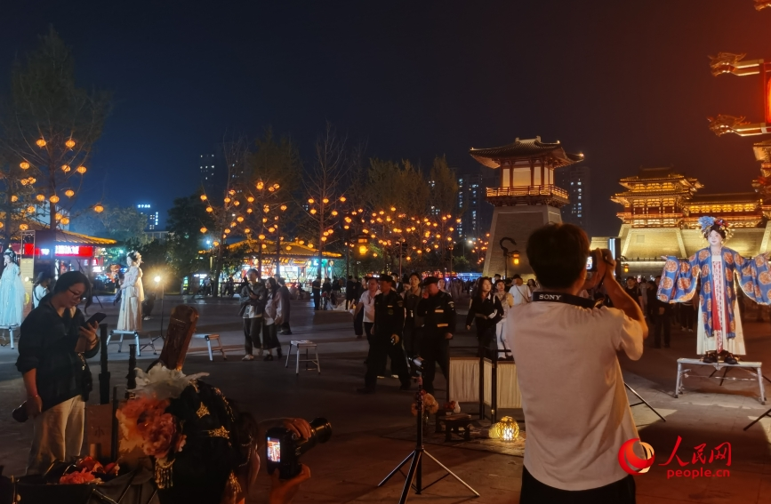 隋唐洛阳城遗址公园的广场上，游客身着汉服拍照打卡。人民网 曹婷摄
