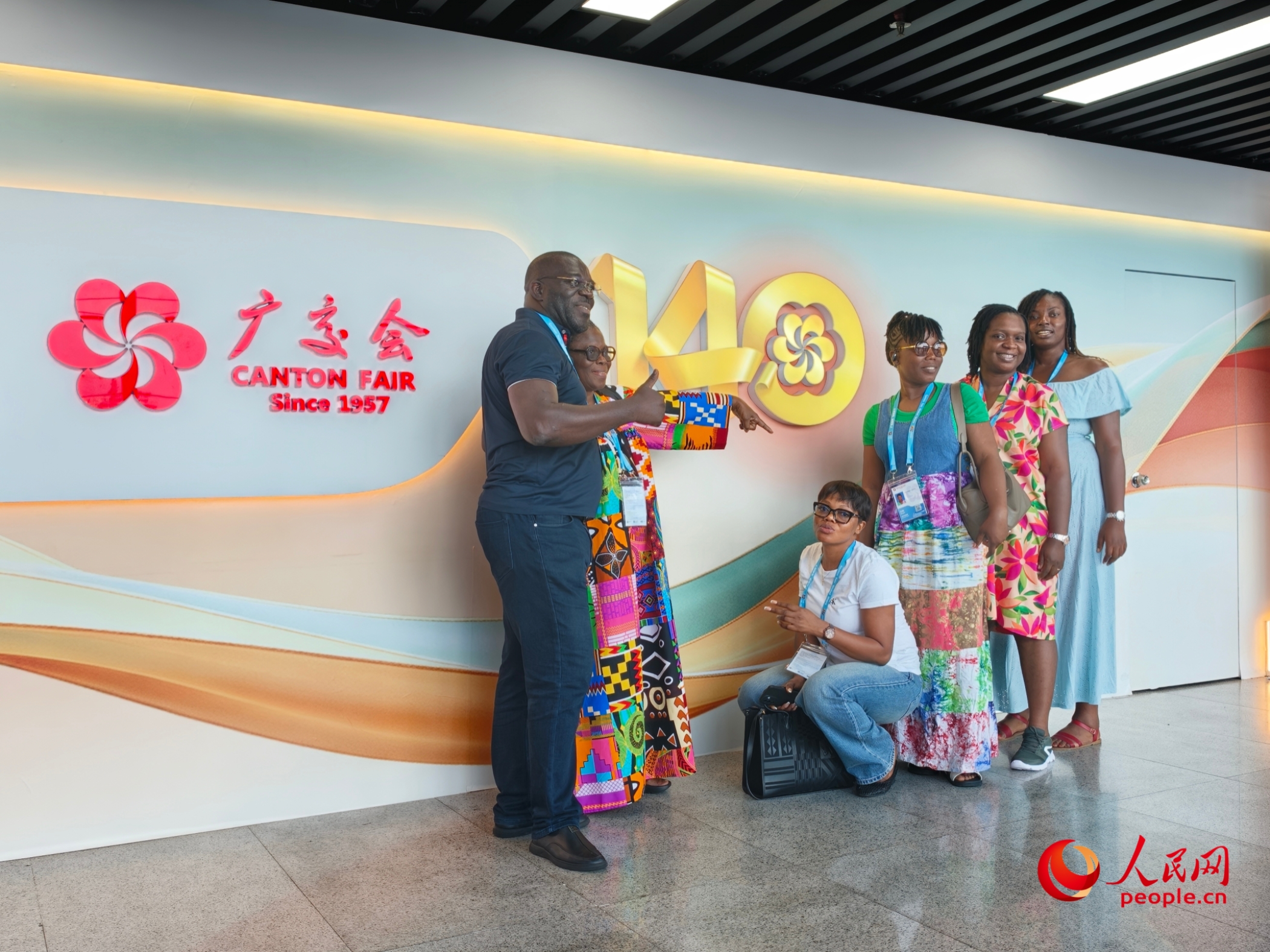 广交会走过70年,多位境外采购商在第140届广交会背景墙合影留念。人民网记者 王雅蝶摄