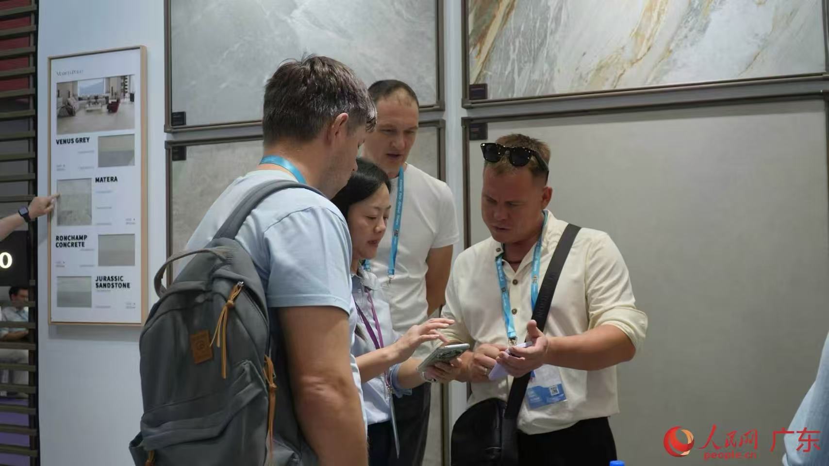 广交会展馆内,境外客商与参展工作人员交流,咨询建材产品价格,洽谈合作事宜。人民网 李舜摄